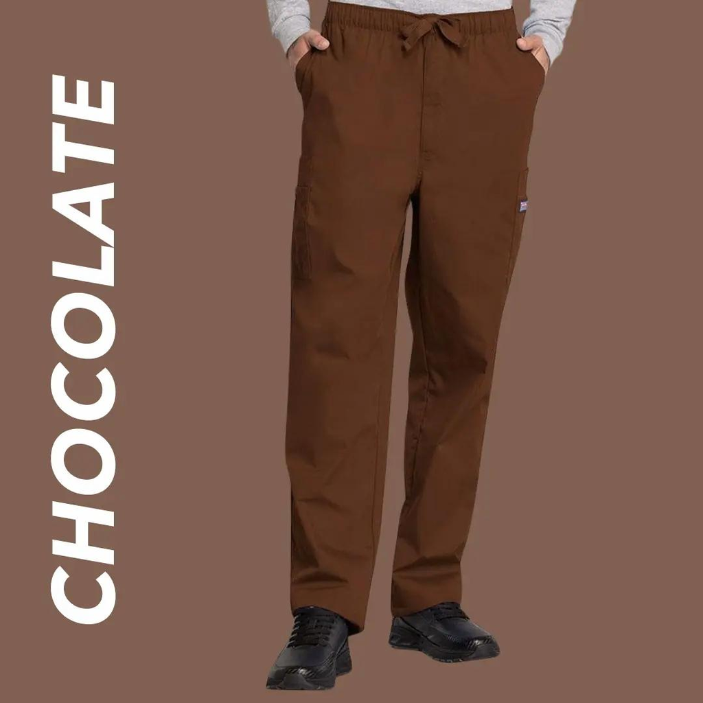 A young man wearing a pair of chocolate colored scrub pants on a light brown background with text to the left stating "Chocolate".