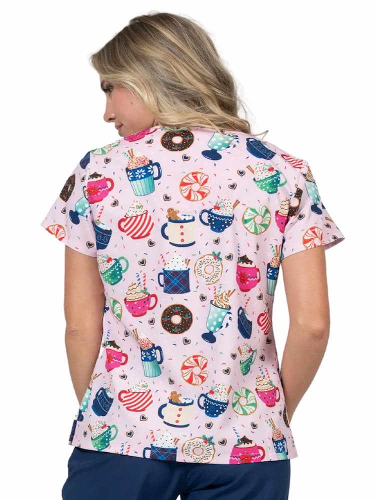 An image of a of the back of a young female registered nurse wearing a Meraki Sport Women's Print Scrub Top in "Mug-nificent size xl featuring short sleeves and shoulder yokes.