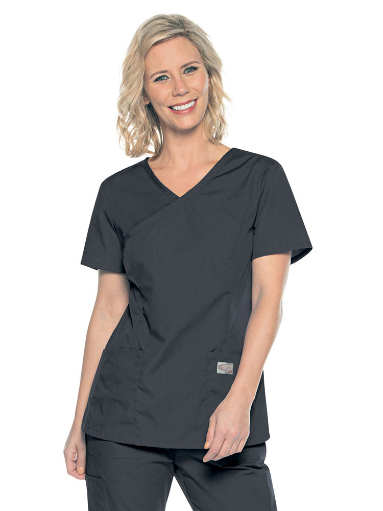 A young female Medical Assistant wearing a Landau ScrubZone Women's Mock Wrap Top in Graphite size Small featuring a modern tailored fit.
