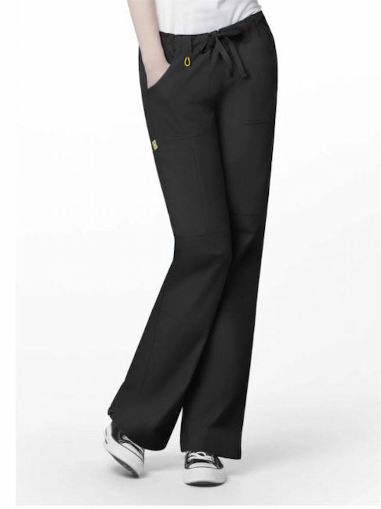 A middle aged female Medical Assistant wearing a pair of the WonderWink Origins Women's Tango Straight Leg Scrub Pants in Black size XL Tall featuring double stitched seaming throughout.