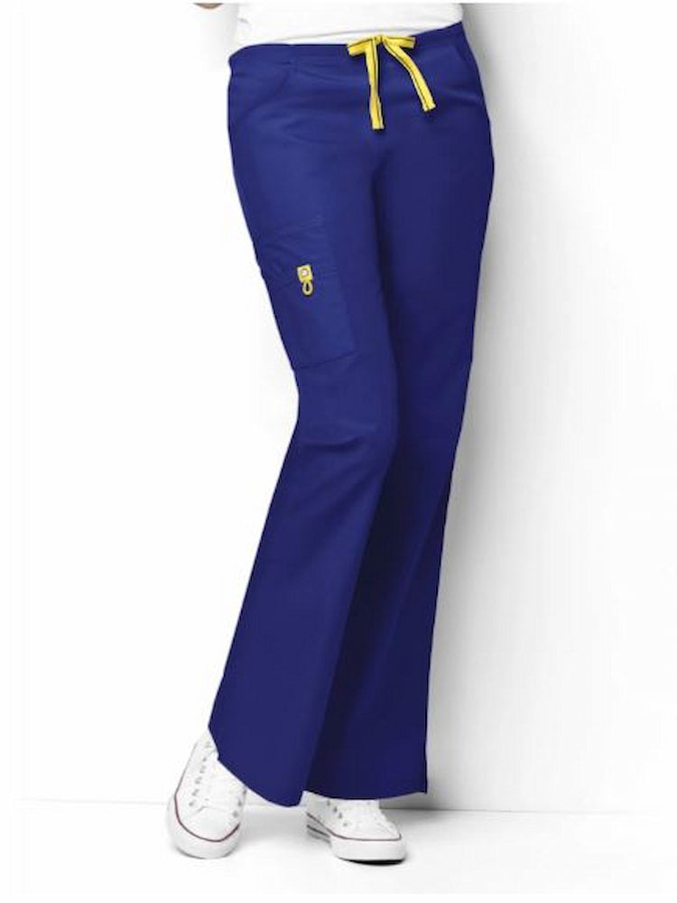 A female Occupational Therapist wearing a WonderWink Women's Romeo Flare Leg Cargo Scrub Pant in Galaxy Blue size XXS featuring a convertible drawstring that allows the drawstring to be tucked inside the pant or shown outside.