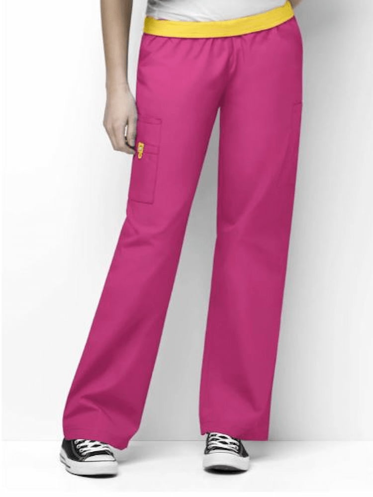A female nurse wearing a pair of WonderWink Women's Elastic Waist Quebec Scrub Pants in Hot Pink size Small Tall featuring a total of 8 pockets.