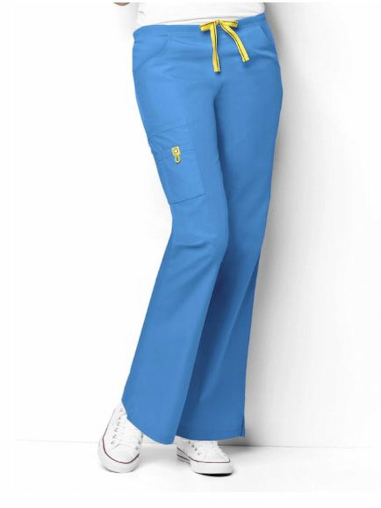 A young female Pharmacy Technician wearing a pair of the WonderWink Women's Romeo Cargo Scrub Pant in Malibu Blue size 3XL Petite featuring a flares at the leg. 