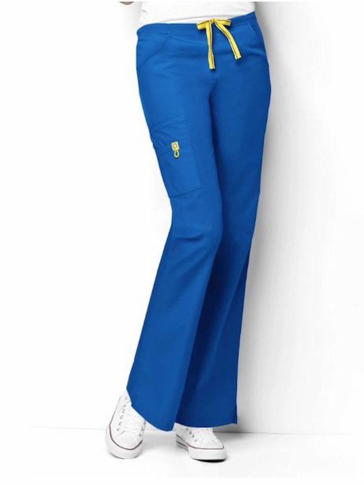A young female Physical Therapist wearing a pair of the WonderWink Origin Women's Romeo Cargo Scrub Pants in Royal size XXS petite featuring 2 front slash pockets.