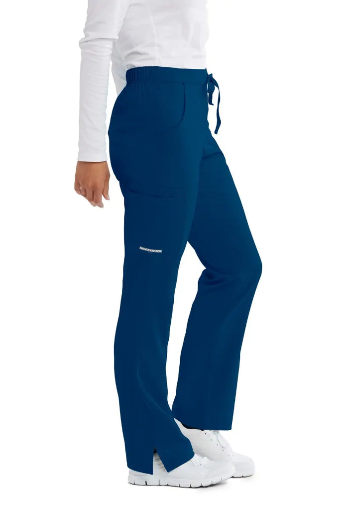 The right side of the Skechers Women's Reliance Cargo Scrub Pants in Navy featuring a side cargo pocket with the Skechers logo on the wearer's right side leg.