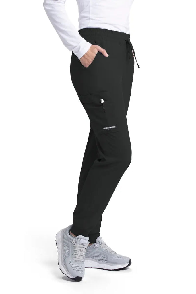 The right side of the Skechers Women's Theory Scrub Jogger in Black featuring an exterior cargo pocket with the Skechers' logo printed on the bottom of the pocket.