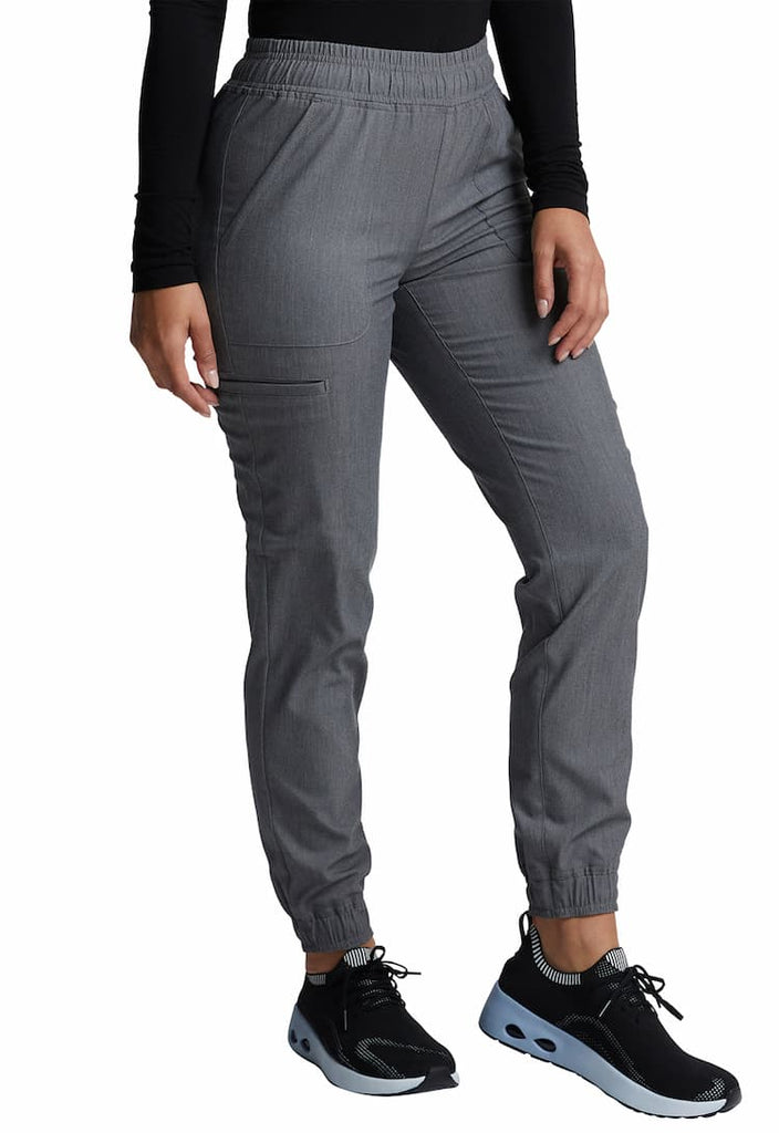 A young female Physician's Assistant wearing a Vince Camuto Women's Mid Rise Scrub Jogger in Heathered Charcoal size XS featuring elasticized cuffs.