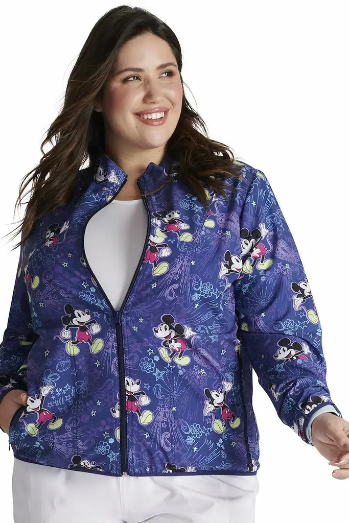 A young female LPN wearing a Tooniforms Women's Packable Print Jacket in "Mickeys Bandana Land" featuring a contemporary fit.