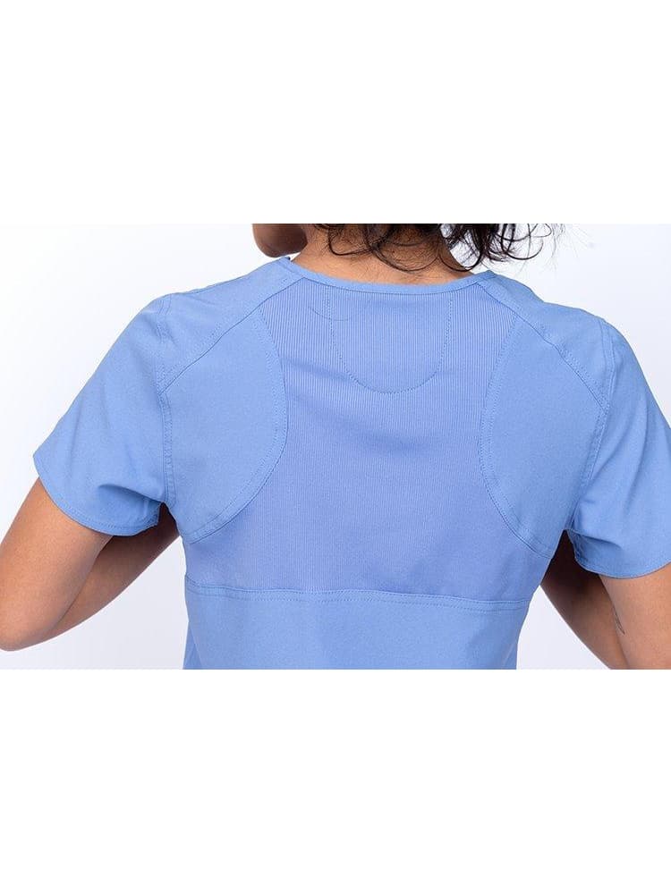An up-close image of the back of the Meraki Sport Women's Mock Wrap Scrub Top in Ceil Blue featuring a center back stretch panel.