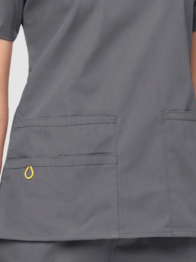 An up close image two lower front pockets on the on the WonderWink Origins Women's Bravo V-neck Scrub Top in Pewter size Medium. 