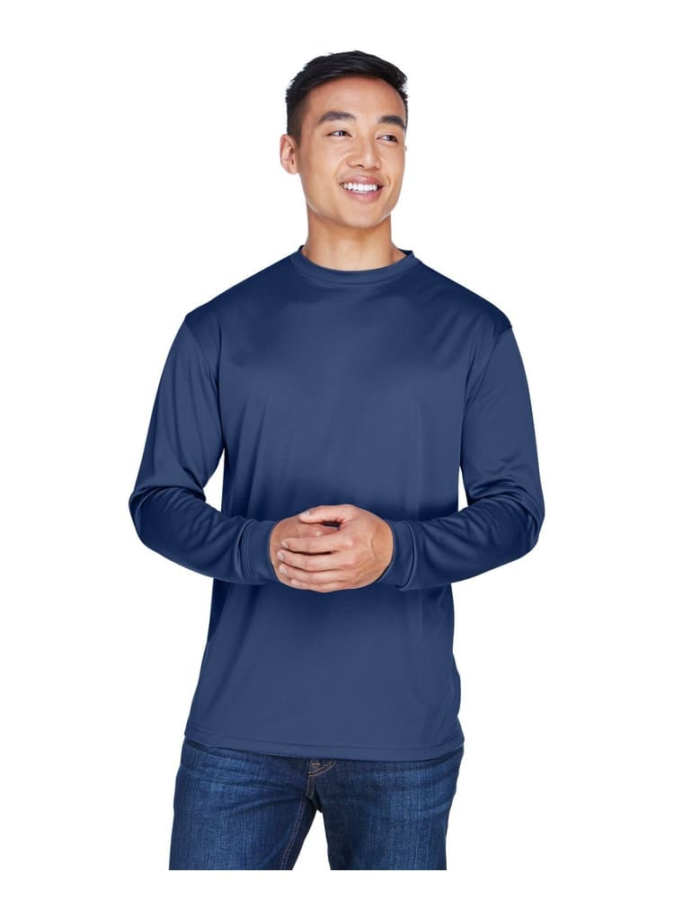 A young male Physical Therapist wearing an UltraClub Men's Cool & Dry Long Sleeve T-Shirt in Navy size XL featuring an athletic design with a moisture wicking fabric to keep you cool & comfortable all day.