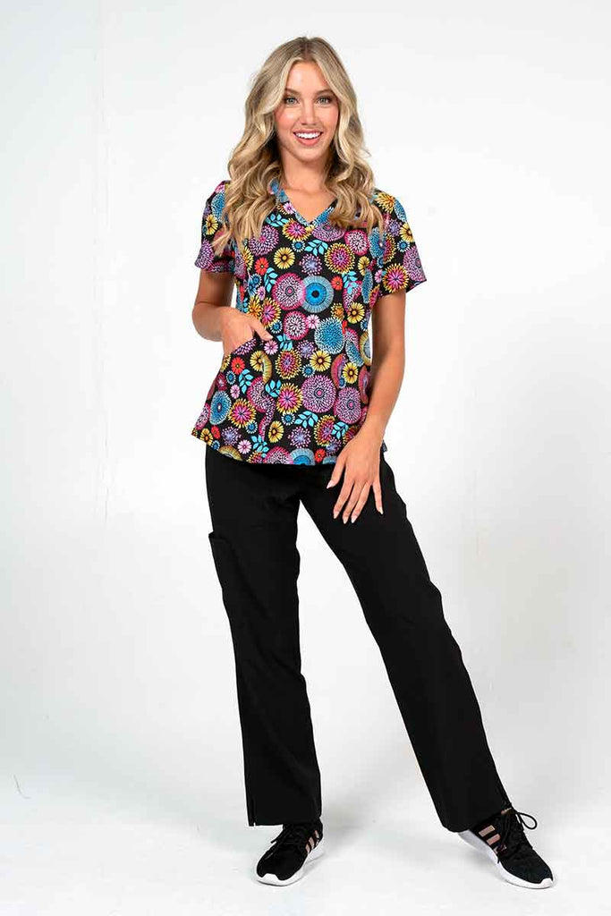 A female LPN wearing a Meraki Sport Women's Print Scrub Top in "Petal Affair" size XL featuring 2 front patch pockets for all of your on the job storage needs.