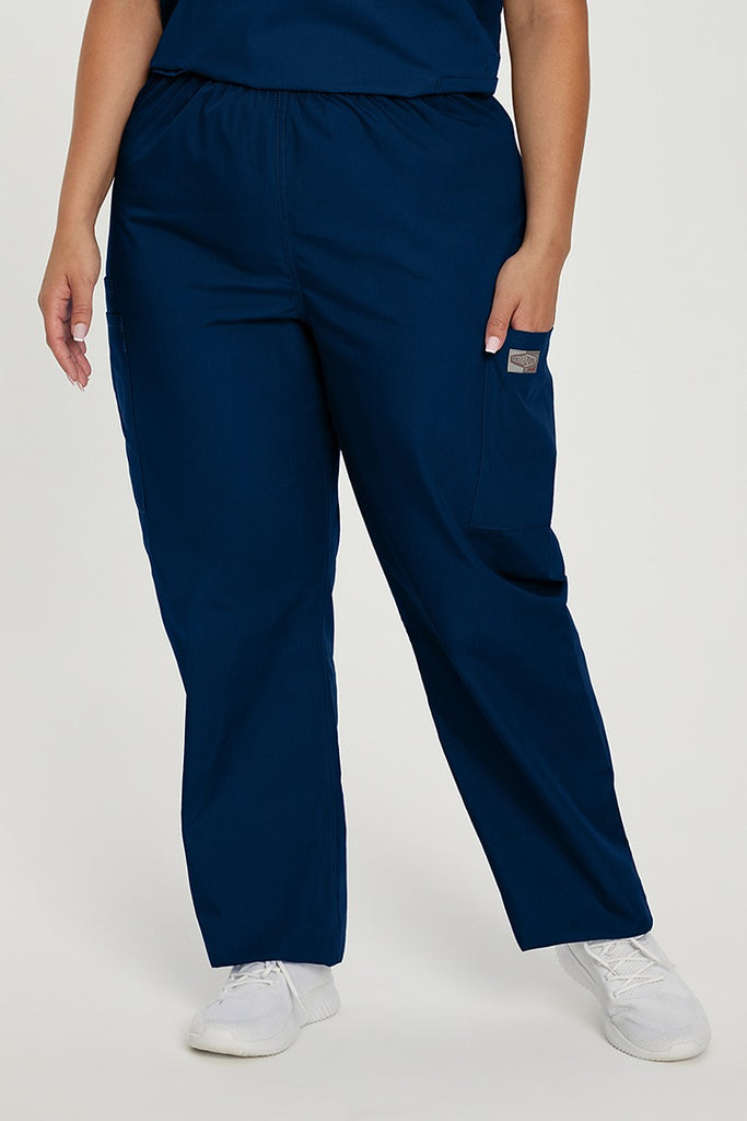 A young female Emergency Medical Technician wearing a Landau ScrubZone Elastic Waist Cargo Scrub Pant in True Navy sixe 3XL featuring a high-rise, triple elastic waist for secure coverage during active movement.
