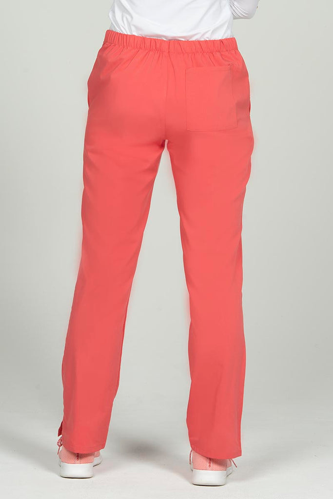 A female RN wearing an Epic by MedWorks Women's Natural Rise Flare Leg Scrub Pant in Coral size 2XL featuring 1 back patch pocket. 