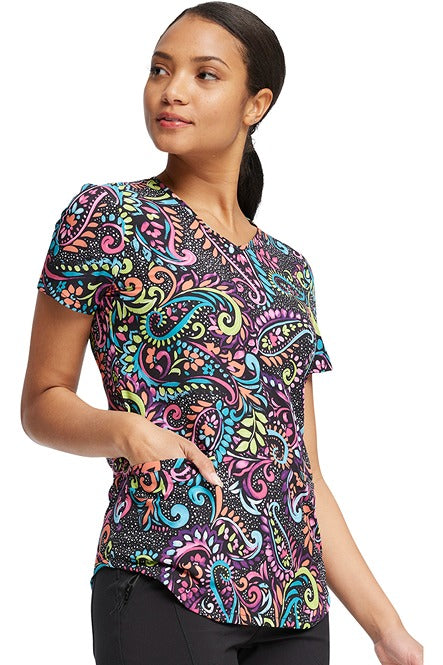 A young female CNA wearing a Cherokee Women's V-Neck Print Scrub Top in "Painted Paisley" featuring fun all over "Paisley" design is perfect for veterinary or pediatric settings!