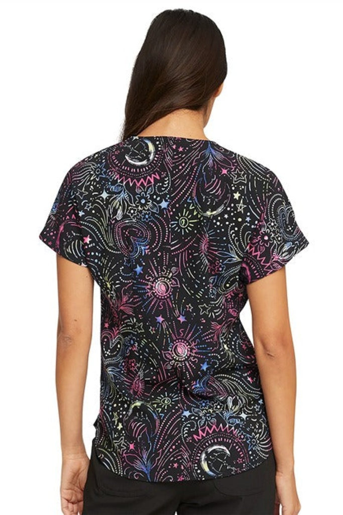 A young female LPN wearing a HeartSoul Women's Round Neck Print Scrub Top in "Celestial Twist" featuring a center back length of 26".