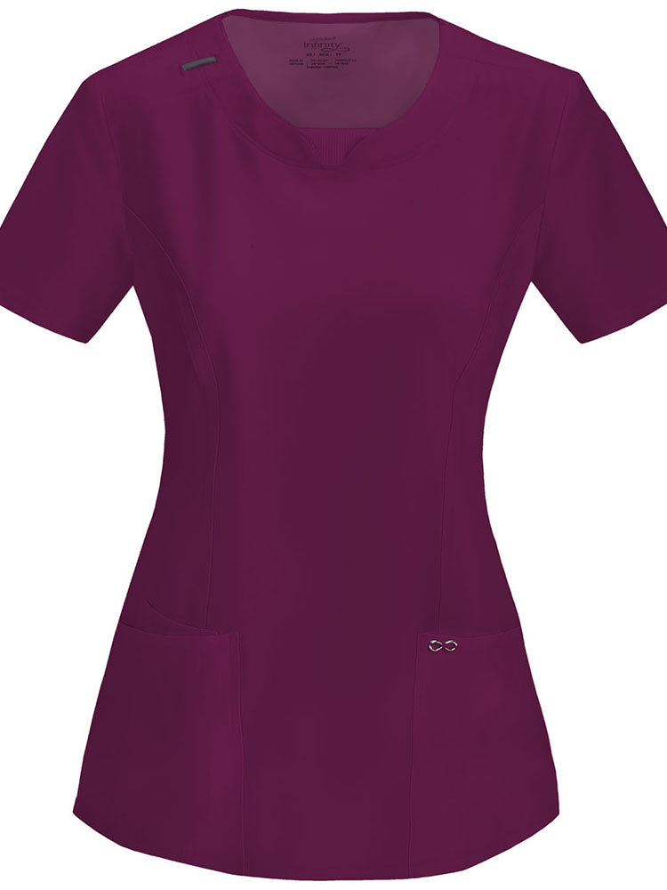 A frontward facing image of the Cherokee Infinity Women's Round Neck Scrub Top in Wine size Small featuring a Bungee I.D. badge loop on the right shoulder.