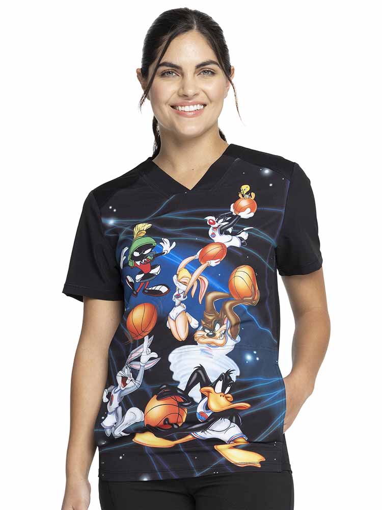 Young woman wearing a Tooniforms Unisex V-Neck Print Scrub Top in "Space Jam" featuring front & back yokes for flattering shaping.