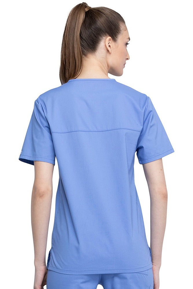 An image of a Female Physician wearing a Cherokee Unisex Tuck-in Scrub Top in Ceil Blue size Medium featuring a center back length of 28".