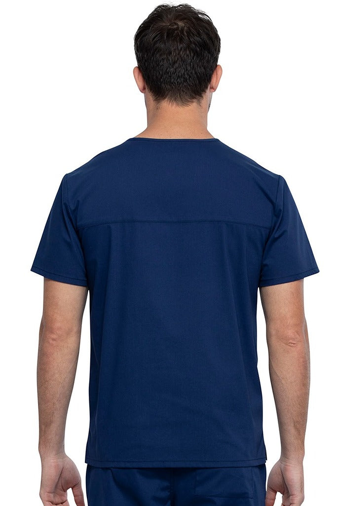 An image of a Male Medical Assistant wearing a Cherokee Unisex Tuckable V-neck Scrub Top in Navy size 3XL featuring a back yoke & dolman sleeves.