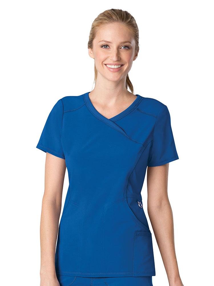 A female Nursing Assistant wearing a Cherokee Infinity Women's Antimicrobial Mock Wrap Top in Royal size small featuring a mock wrap Y-neckline.