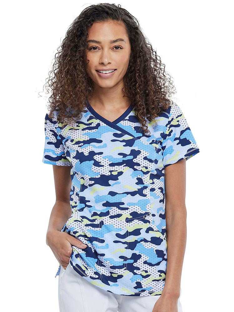 Young nurse wearing a Women's Mock Wrap Print Top in Polka Dot Camo from Infinity by Cherokee.
