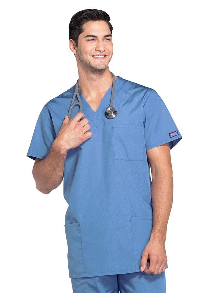 A young male Registered Nurse wearing a Cherokee Workwear Originals Unisex Multi-Pocket V-neck Scrub Top in Ceil size 3XL featuring 2 front patch pockets.