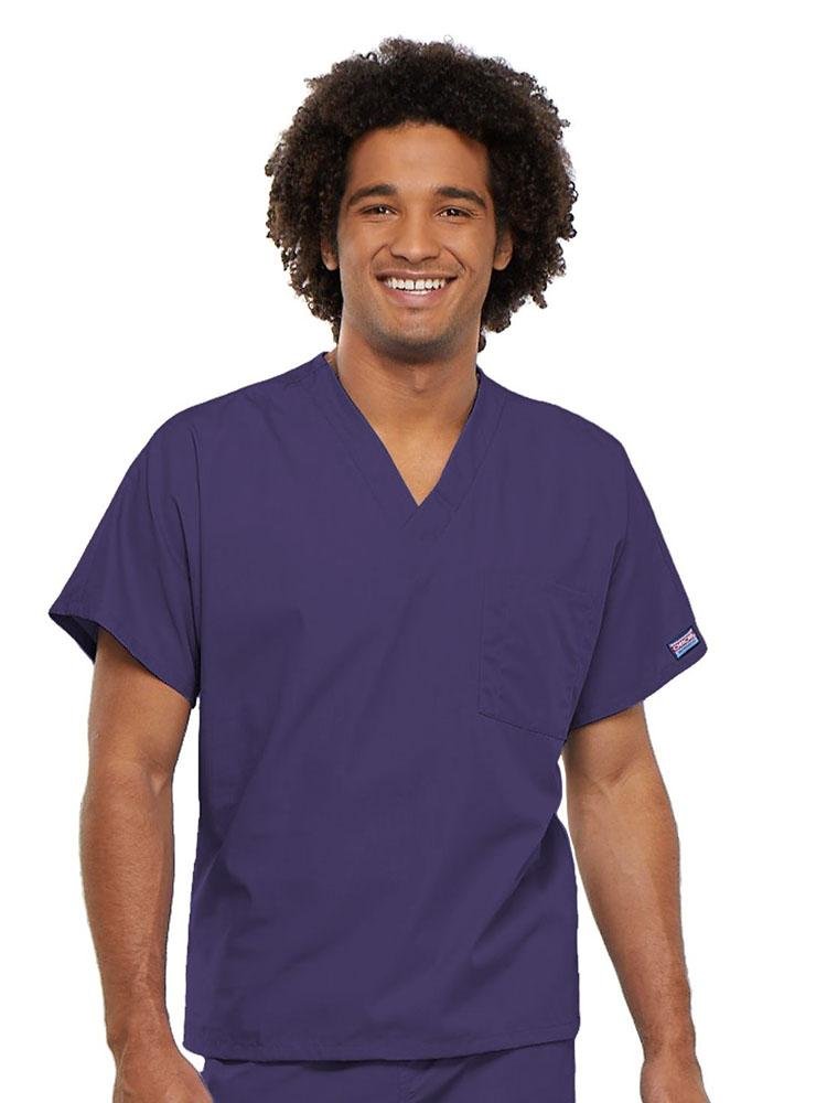 A young male Physician's Assistant wearing a Cherokee Workwear Originals Unisex Single Pocket V-neck Scrub Top in Grape size XL featuring short sleeves.