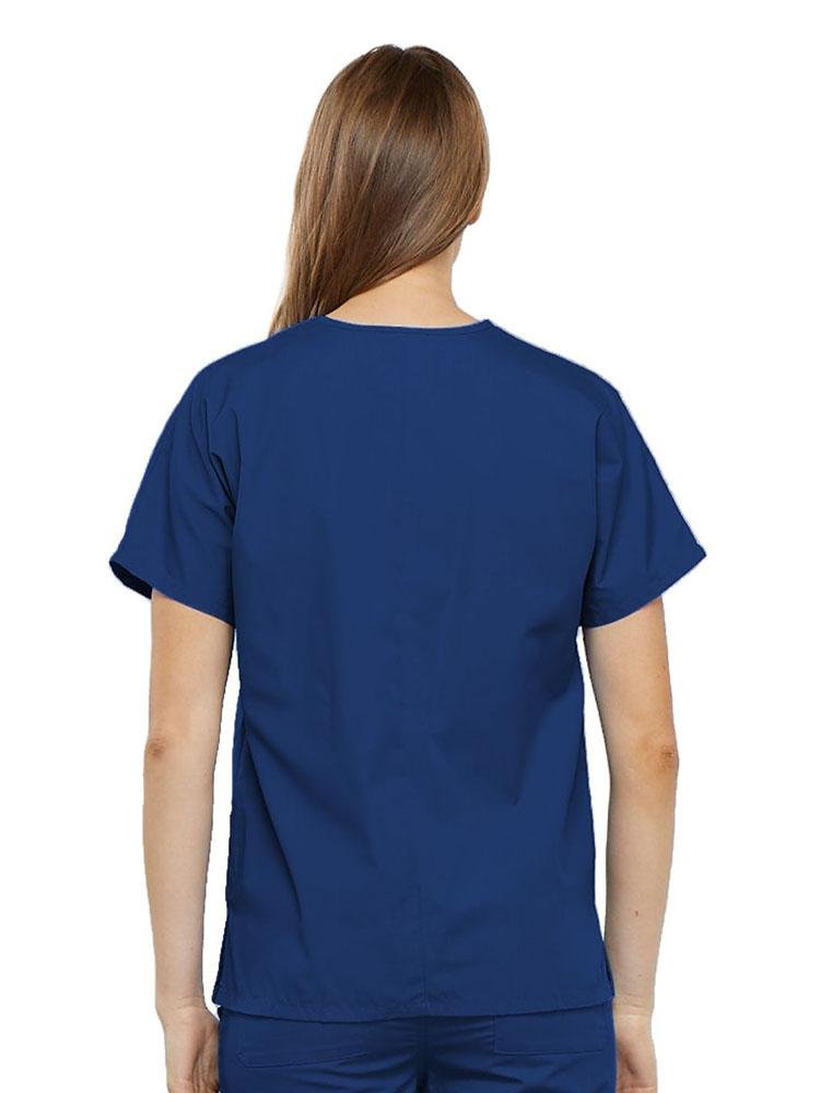 A young female Surgical Technologist wearing a Cherokee Workwear Originals Women's V-neck Scrub Top in Galaxy Blue size 2XL featuring a center back length of 26.5".