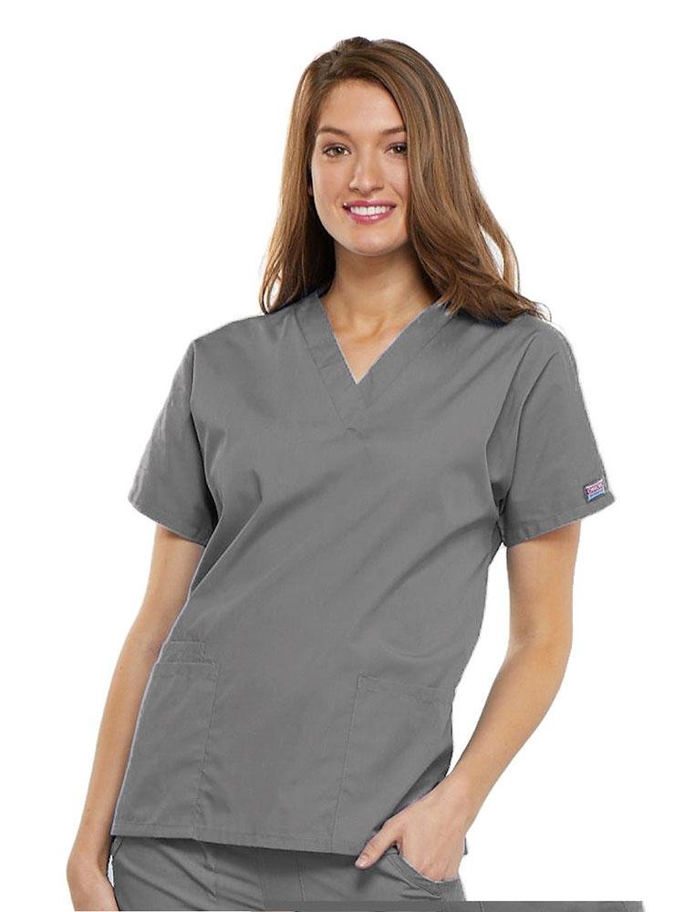 A young female Psychiatric Aide wearing a Cherokee Workwear Originals Women's V-neck Scrub Top in Grey size 2XL featuring short sleeves.