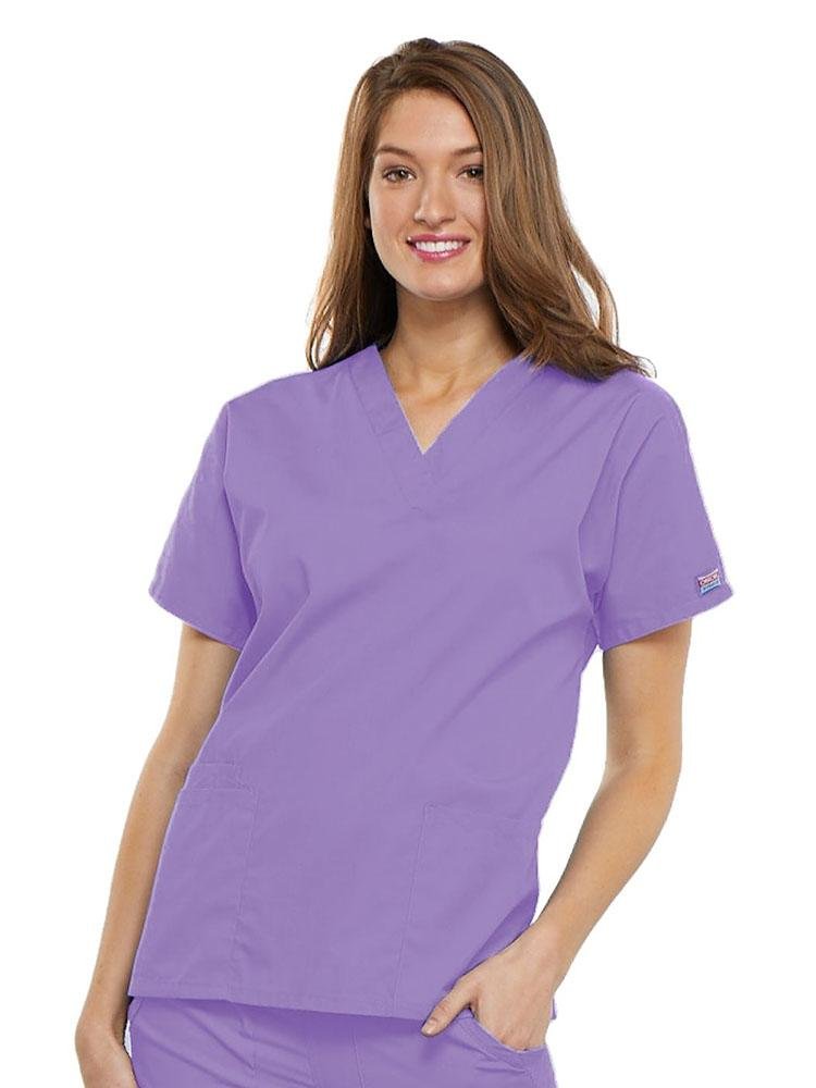 A young female EMT wearing a Cherokee Workwear Originals Women's V-neck Scrub Top in Orchid size 3XL featuring short sleeves.