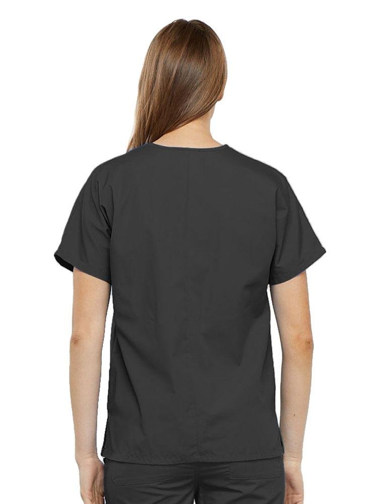 A young female Home Health Aide wearing a Cherokee Workwear Originals Women's V-neck Scrub Top in Pewter size medium featuring a center back length of 26.5".