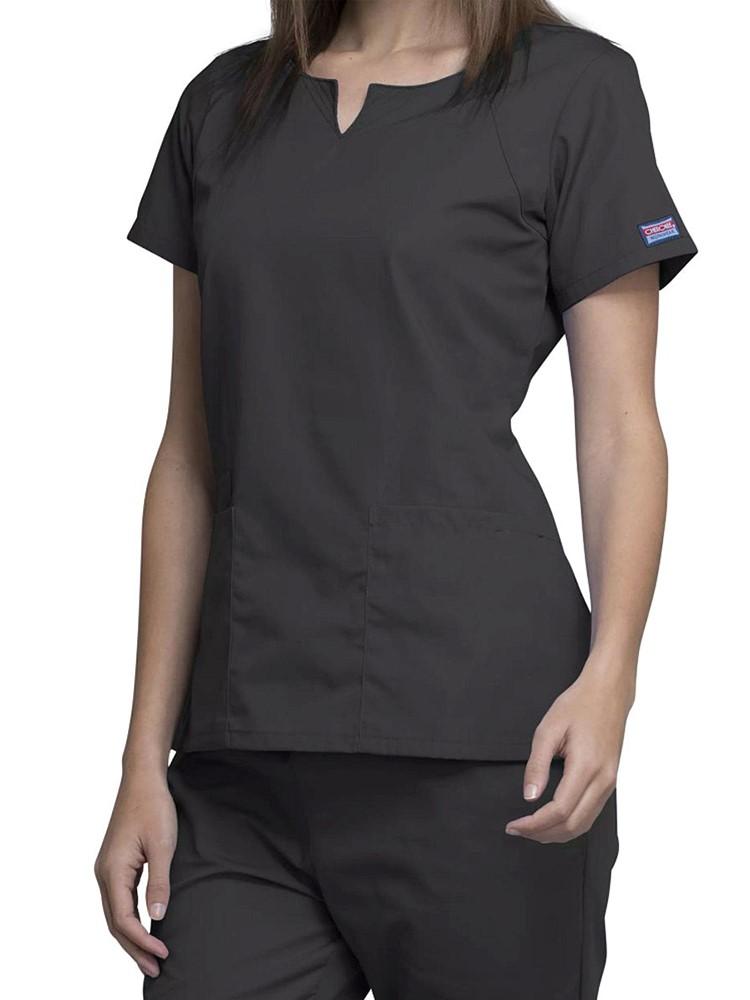 A female Physician wearing a Cherokee Workwear Originals Women's Notch Crew Neck Round Neck Scrub Top in Pewter size Small featuring a a total of 4 pockets for all of your on the job storage needs.