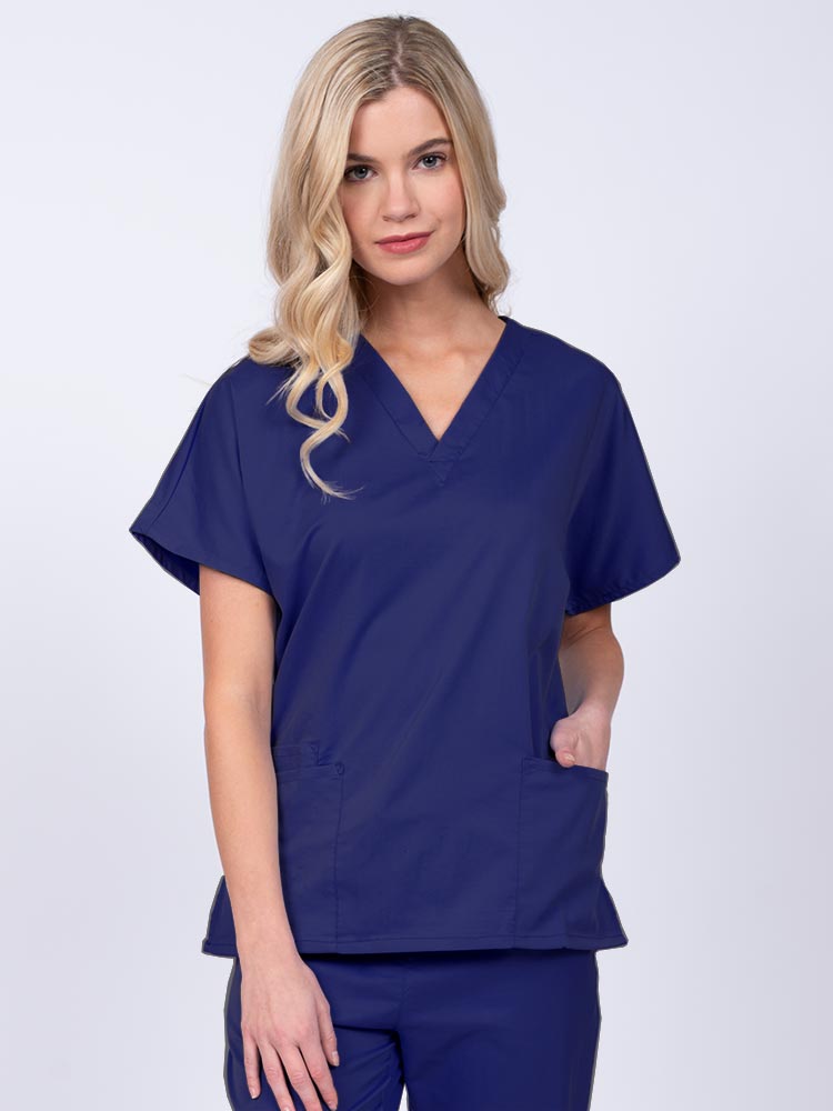 Young nurse wearing an Epic by MedWorks Unisex V-Neck Scrub Top in navy with a unique, easy care fabric made of 77% polyester, 21% Viscose and 2% Spandex.
