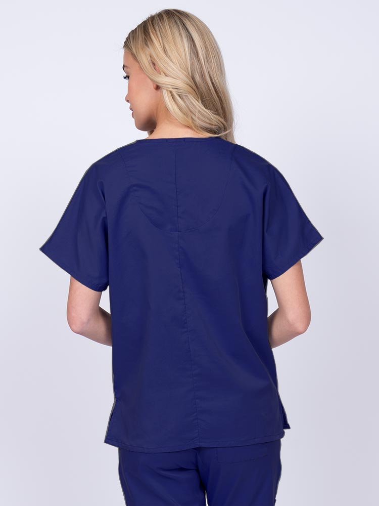 Woman wearing an Epic by MedWorks Unisex V-Neck Scrub Top in navy with a center back length of 27.5".