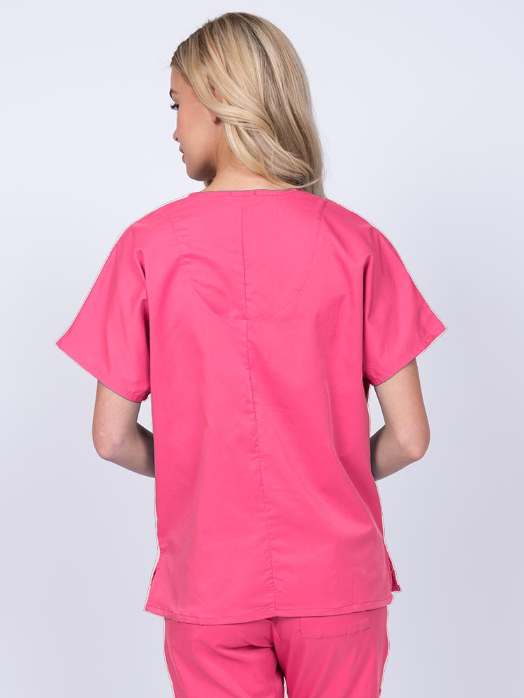 Woman wearing an Epic by MedWorks Unisex V-Neck Scrub Top in shocking pink with a center back length of 27.5".