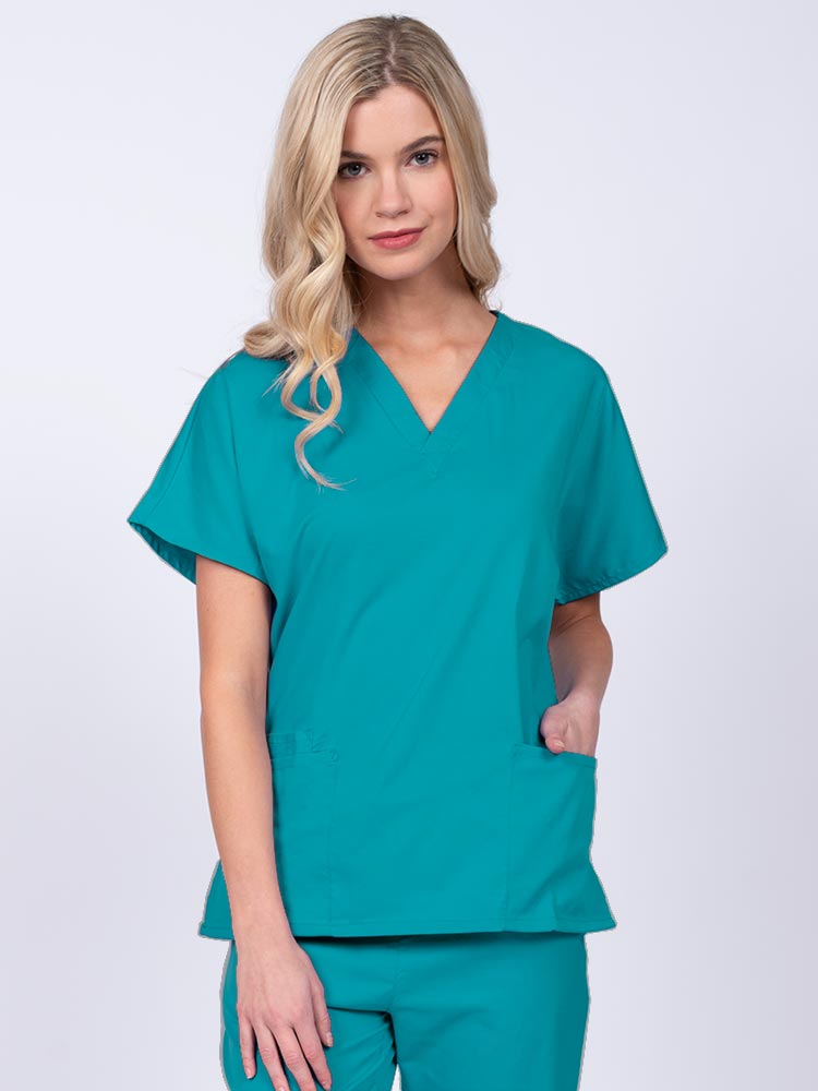 Young nurse wearing an Epic by MedWorks Unisex V-Neck Scrub Top in teal with a unique, easy care fabric made of 77% polyester, 21% Viscose and 2% Spandex.