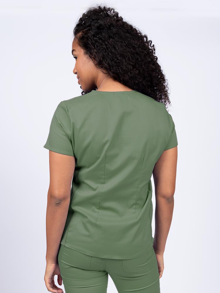 Woman wearing an Epic by MedWorks Women's Blessed Scrub Top in olive with a pleated back for a flattering fit.