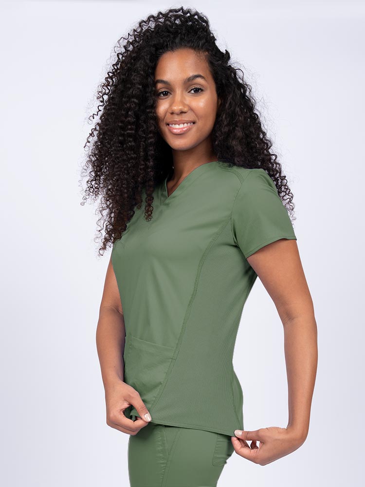 Nurse wearing an Epic by MedWorks Women's Blessed Scrub Top in olive with stylish seaming throughout.