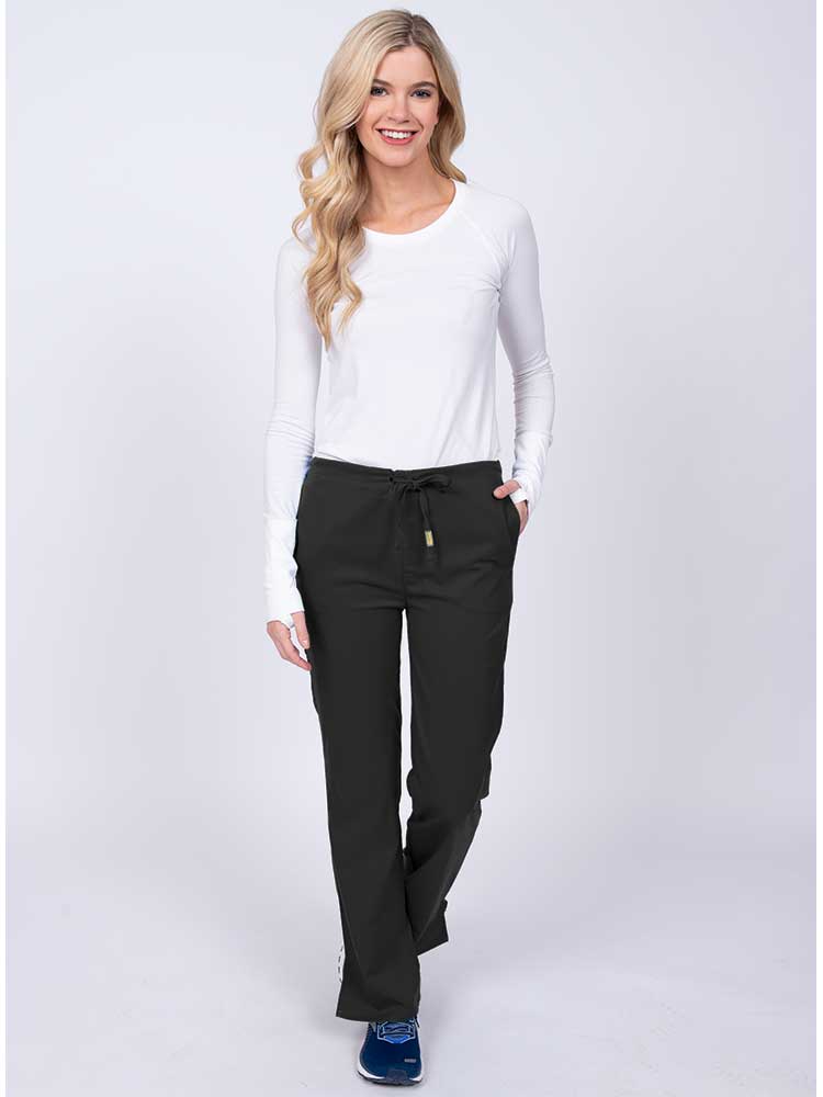 Woman wearing an Epic by MedWorks Women's Drawstring Flare Leg Scrub Pant in black with 2 front slash pockets & 1 back pocket.