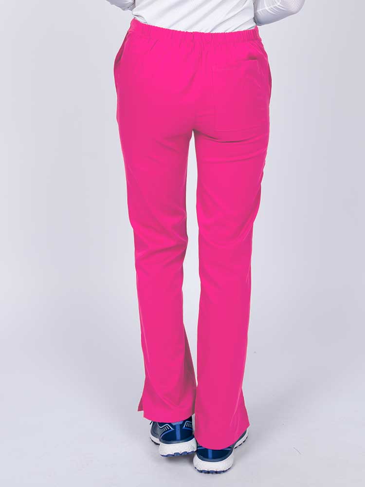Young healthcare worker wearing an Epic by MedWorks Women's Drawstring Flare Leg Scrub Pant in shocking pink featuring a drawstring waist with back elastic.