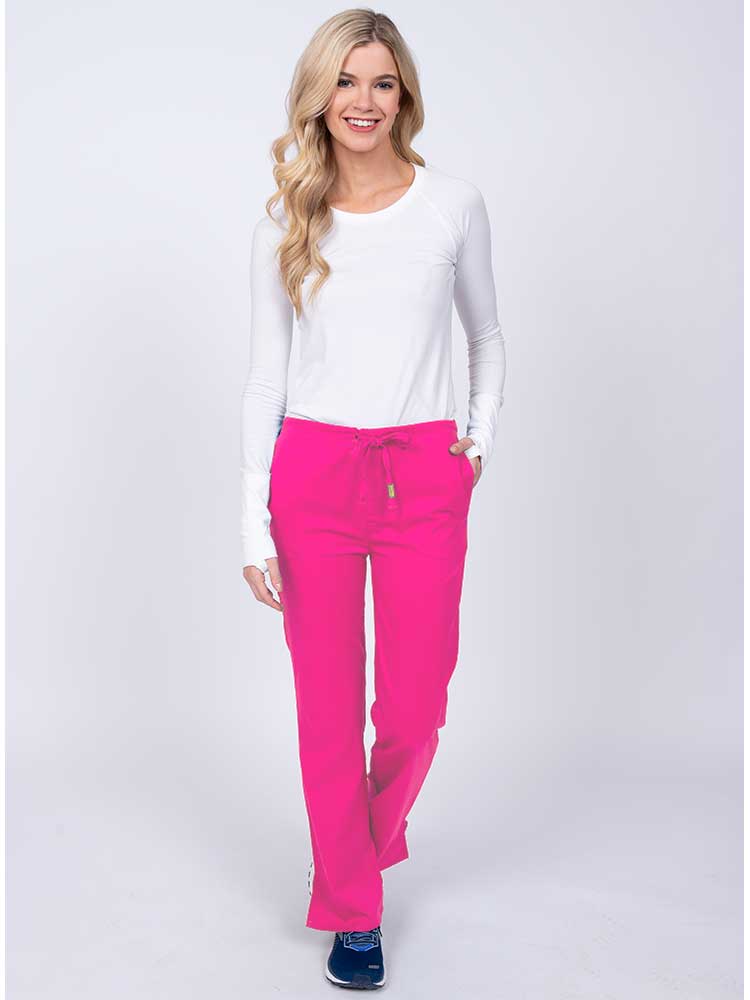 Woman wearing an Epic by MedWorks Women's Drawstring Flare Leg Scrub Pant in shocking pink with 2 front slash pockets & 1 back pocket.