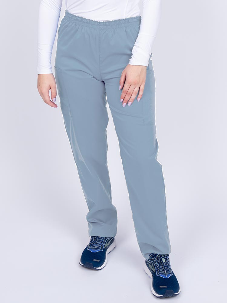 Young woman wearing an Epic by MedWorks Women's Elastic Waist Scrub Pant in blue fog featuring a tapered leg and elastic waist.
