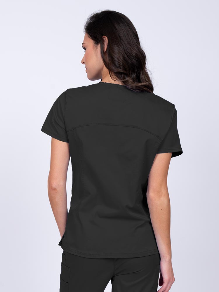 Young female nurse wearing an Epic by MedWorks Women's Knit Collar Mock Wrap Scrub Top in black with stylish seaming throughout.
