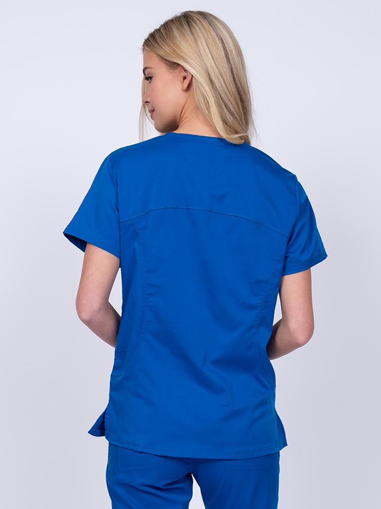 Young female nurse wearing an Epic by MedWorks Women's Knit Collar Mock Wrap Scrub Top in royal with stylish seaming throughout.