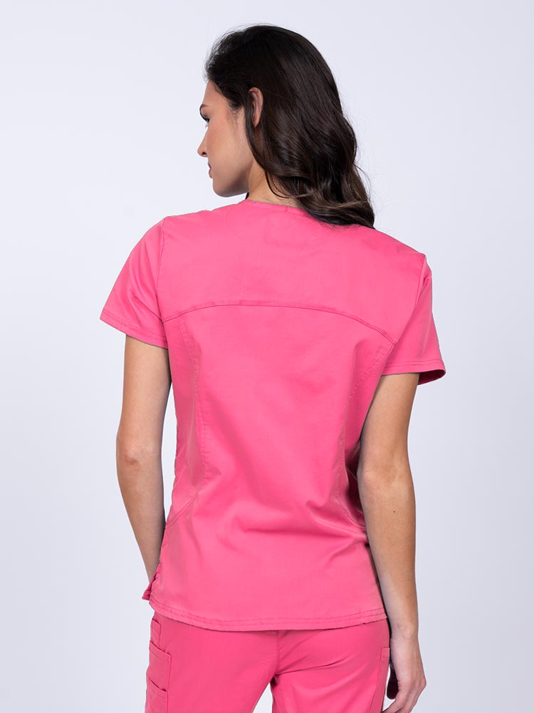 Young female nurse wearing an Epic by MedWorks Women's Knit Collar Mock Wrap Scrub Top in shocking pink with stylish seaming throughout.