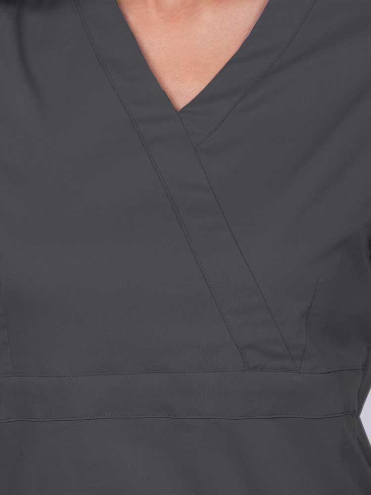 Young woman wearing an Epic by MedWorks Women's Mock Wrap Scrub Top in pewter featuring a mock wrap neckline and stylish front seaming.