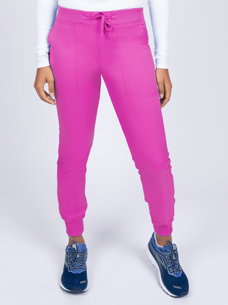 A young female Phlebotomist wearing an Epic by MedWorks Women's Yoga Jogger Scrub Pant in Shocking Pink size 3XL featuring a contemporary fit.