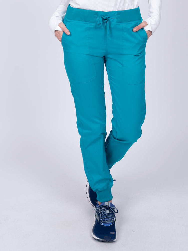 A young female Phlebotomist wearing an Epic by MedWorks Women's Yoga Jogger Scrub Pant in Teal size 3XL featuring a contemporary fit.