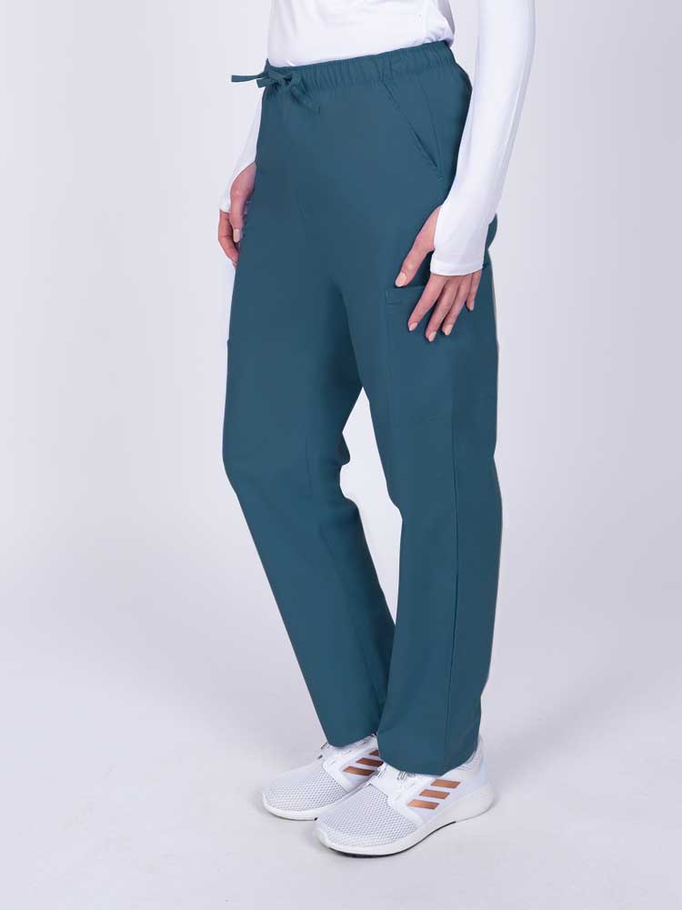 Woman wearing a Luv Scrubs by MedWorks Women's Elastic Waist Cargo Pant in Caribbean with 2 front slash pockets.
